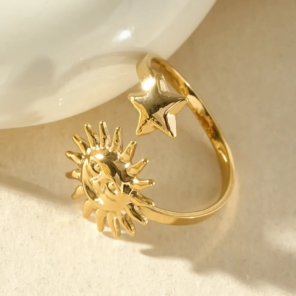 Detalhe do material e do acabamento — Anel dourado aberto sol rosto e estrela