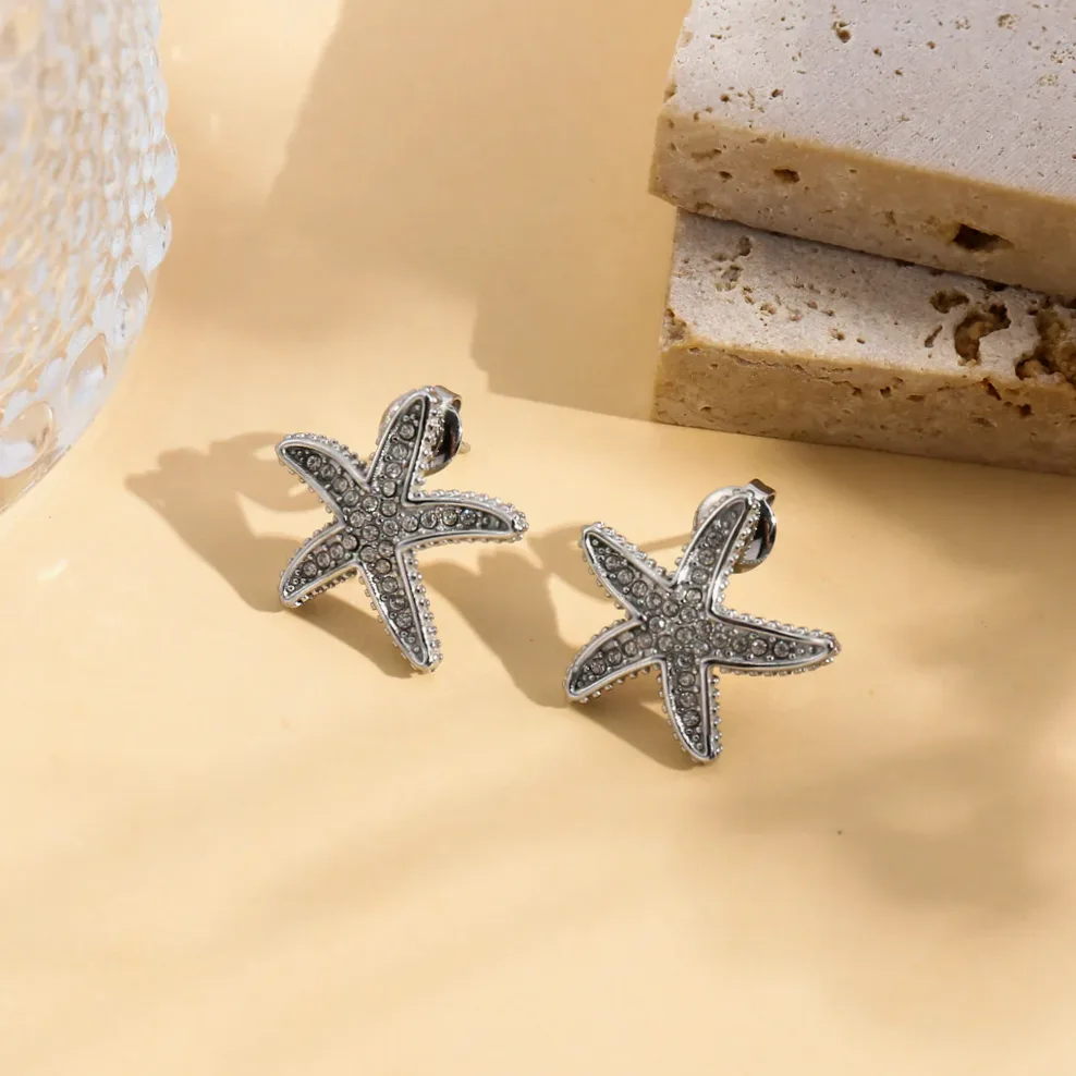 Starfish stud earrings rhinestone embellished gold worn on the ear