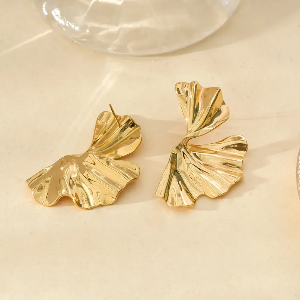 Detalle del material y acabado — Pendientes dorados media flor diseño moderno
