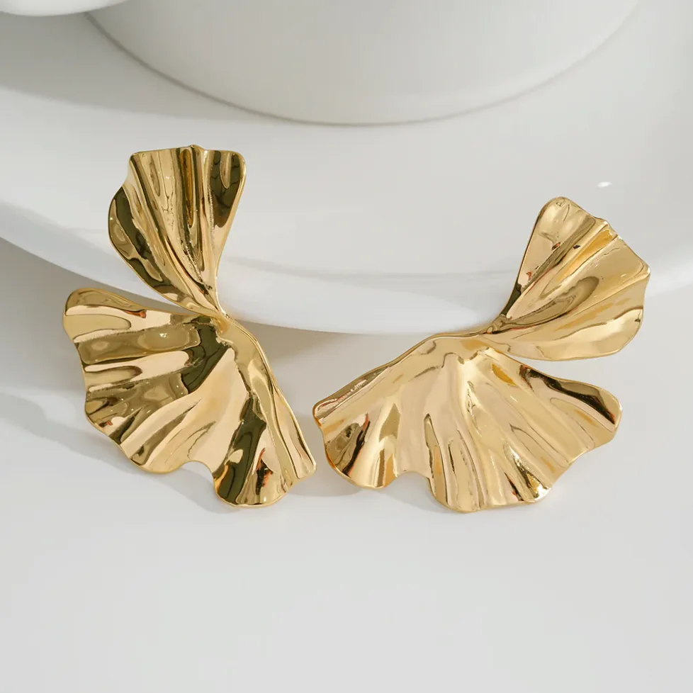 Pendientes dorados media flor diseño moderno puesto en la oreja