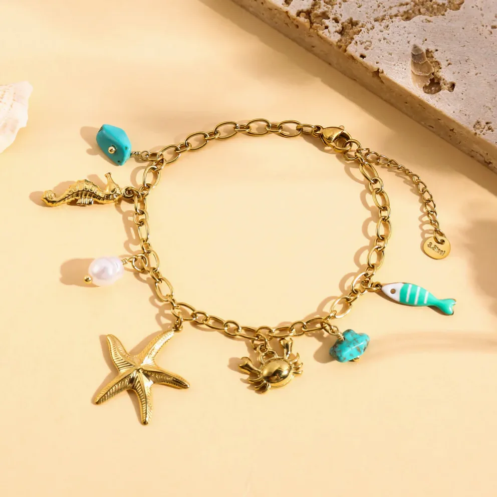 Detalhe do material e do acabamento — Pulseira dourada charms estrela do mar peixe turquesa