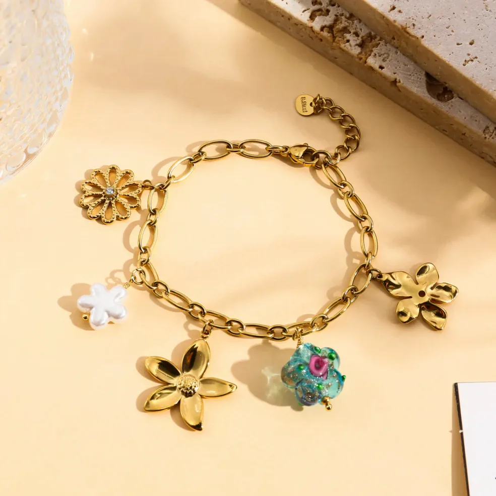 Pulseira dourada charms flor e pérola usado no pulso