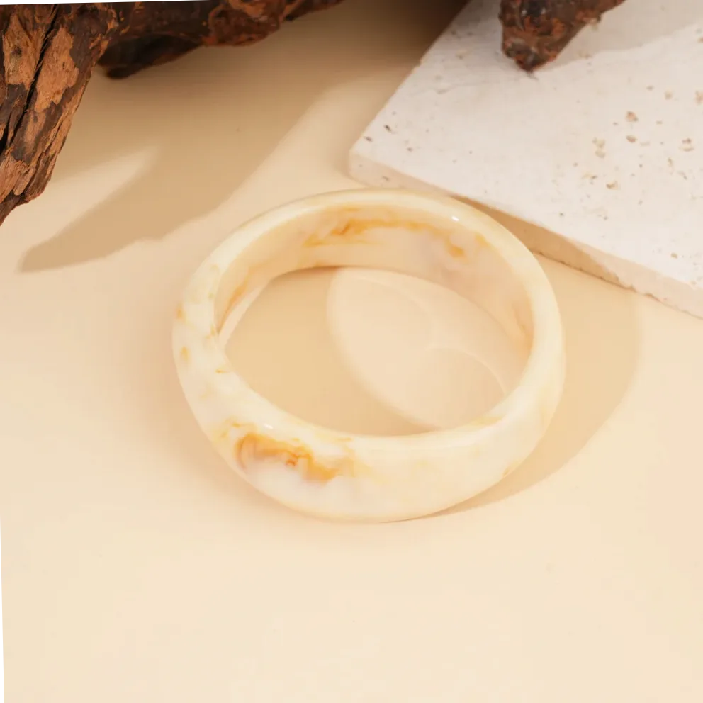 Detalle del material y acabado — Pulsera rígida resina beige forma redonda moderna