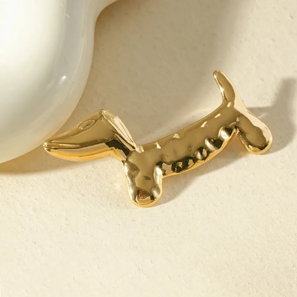 Detalhe do material e do acabamento — Broche dourada cachorro dachshund martelado