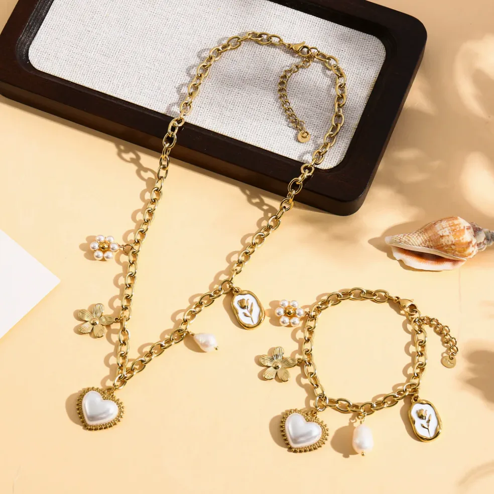 Detalhe do material e do acabamento — Colar dourado coração com pérolas e flores delicadas