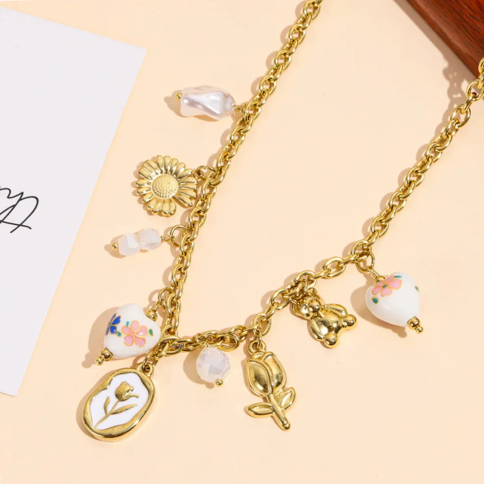 Detalle del material y acabado — Collar dorado charms florales y corazones porcelana