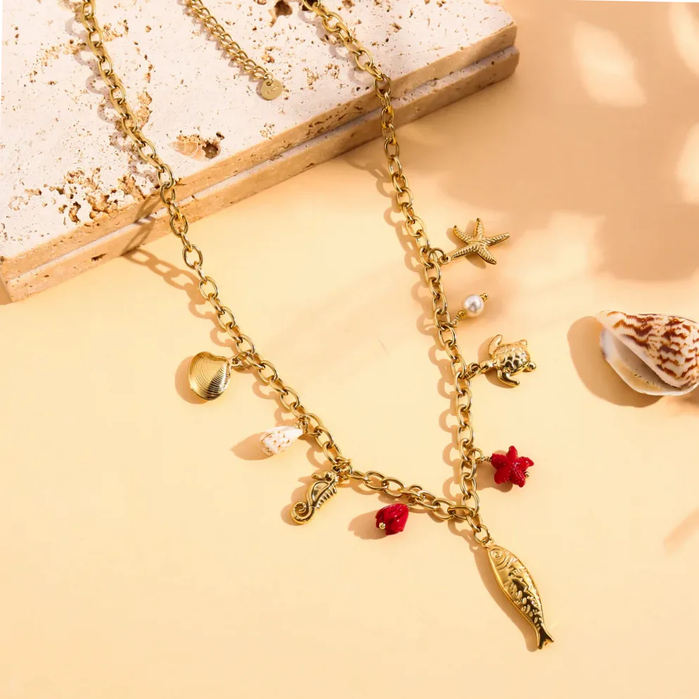 Colar dourado com charms peixe e estrela do mar usado no pescoço