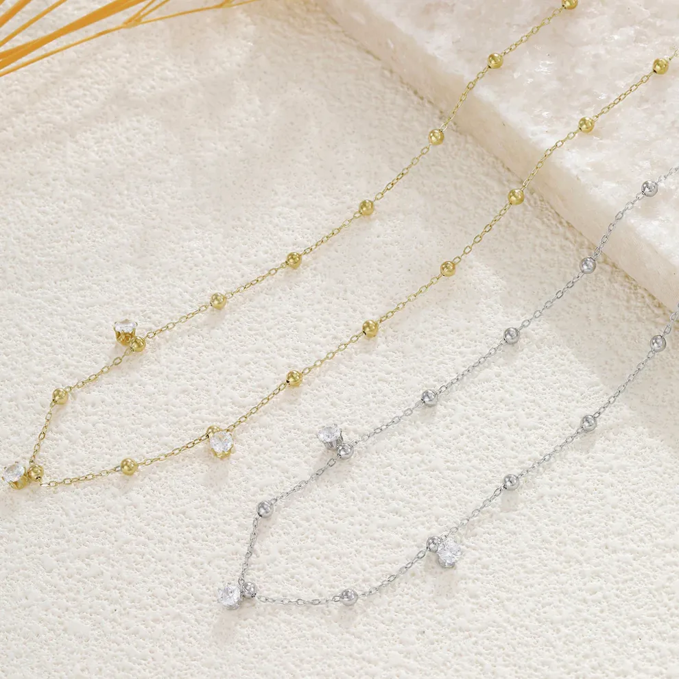 Detalhe do material e do acabamento — Colar dourado fino bolas lisas três strass