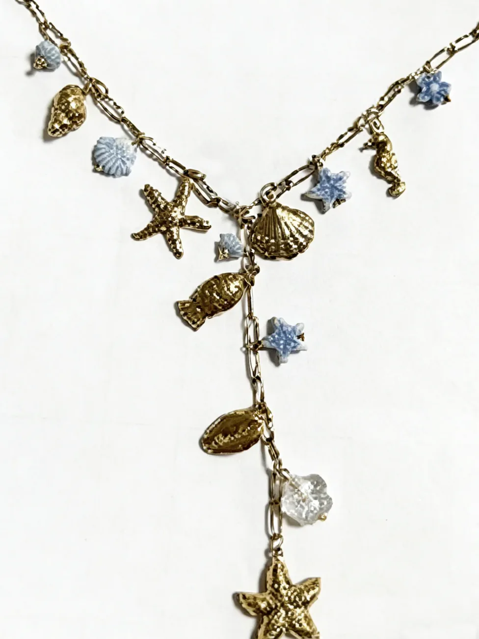 Gold Y necklace marine charms light blue flowers worn around the neck