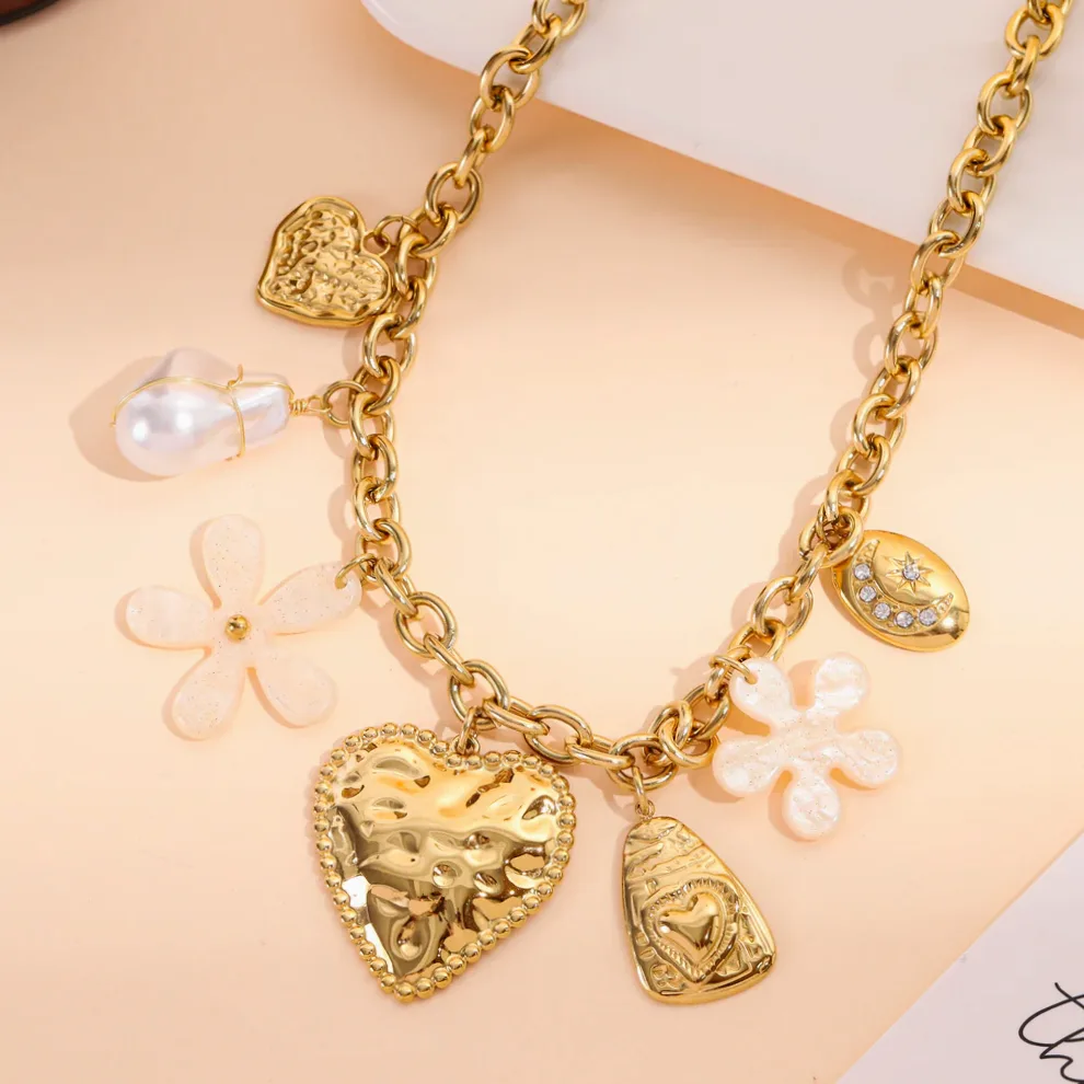 Detalhe do material e do acabamento — Colar dourado com corações esculpidos e flores em resina