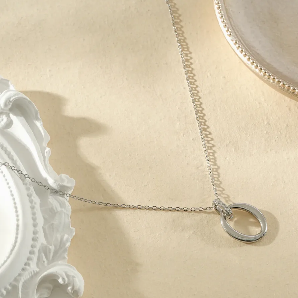 Collier fin orné d’ovales de tailles différentes et d’un ovale strassé porté à la cheville